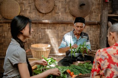 Halktan taze organik sebzelerle yerel çiftçilerin yer aldığı canlı bir pazar sahnesi.