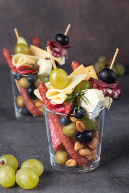 İki bardaktaki Jarcuterie çeşitli sosisler, turşular, peynir, fındık, sebze ve meyveler içerir. Çerezin modern versiyonu, dikey resim