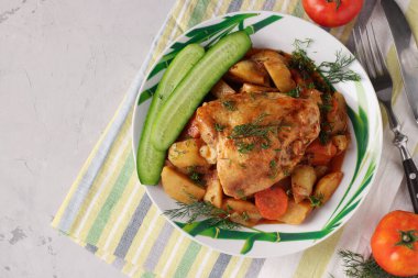 Patates ve havuçla pişirilmiş tavuk butları.