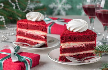 İki porsiyon kırmızı kadife pasta, şarap ve gri arka planda hediyeler, yeni yıl için tatlı.