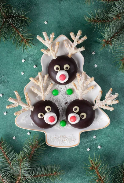巧克力 棉花糖和椰子片做成的增强剂放在绿底圣诞树形的盘子里 顶部视图 — 图库照片