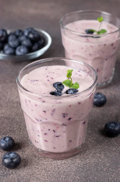 stock image Homemade smoothie with blueberries in two glasses on brown background, Vertical image