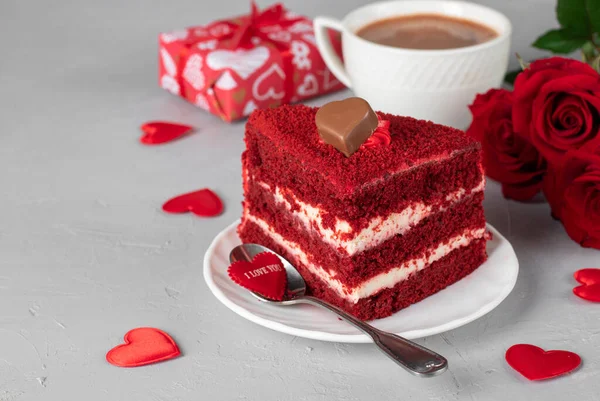 Piece of Red Velvet cake, cup of coffee, roses and gift for Valentines Day or birthday on light gray background