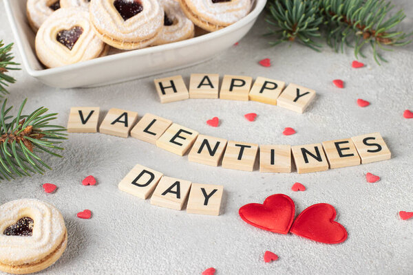 Домашний песочный хлеб с малиновым вареньем в форме сердца, а также деревянные буквы С Днем Святого Валентина на сером фоне