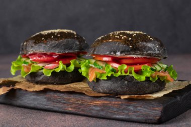 İki vejetaryen siyah burger ve tuzlu somon, yengeç eti ve sebze.