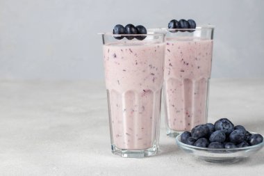 Hafif arka planda uzun gözlüklü yabanmersinli ev yapımı smoothie, boşluğu kopyala