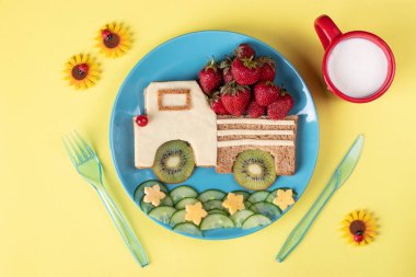 Sarı arka planda çilekli, kivili ve peynirli çocuklar için sağlıklı tost.