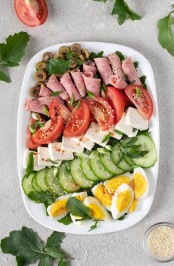 Jambonlu, peynirli, salatalı, domatesli, zeytinli ve yumurtalı sağlıklı salata. Ketogenik öğle yemeği. Üst görünüm