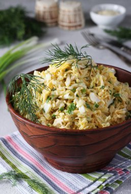 Tavuklu salata, Çin lahanası, haşlanmış yumurta ve peynir gri arka planda kahverengi salata kasesinde, dikey formatta.