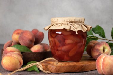 Ev yapımı şeftali reçeli. Cam kavanozda. Tahta üzerinde.