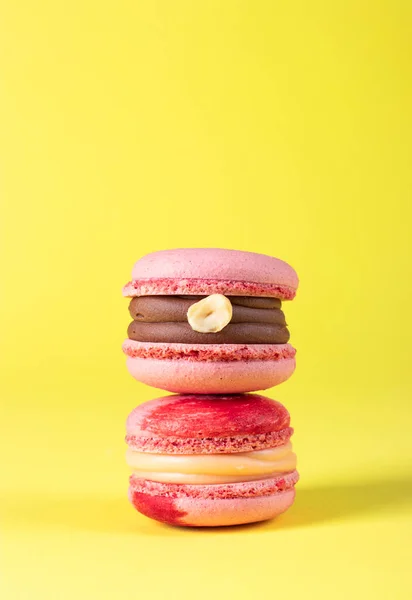 Dois Macarons Rosa Com Avelãs Caramelo Sobre Fundo Amarelo Imagem — Fotografia de Stock
