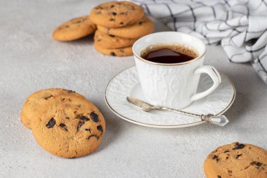 Bir fincan kahve ve arka planda çikolata olan ev yapımı kurabiye.