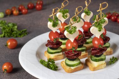 Peynirli kanepe, vişneli domates, sosis ve siyah zeytin.