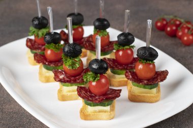 Kiraz domatesli kanepe, sosis, peynir ve siyah zeytin.