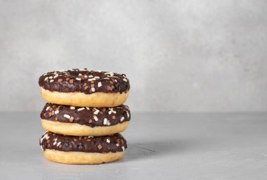 Gri arka planda çikolata jöleli üç çörek, mesaj için Spacy.