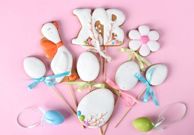 Paskalya zencefilli kurabiyeleri pembe arka planda yumurta şeklinde. Paskalya tebrik kartı. Üst görünüm