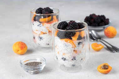 Böğürtlenli Chia pudingi ve gri arka planda kayısı.