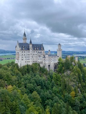 Neuschwanstein Castle in southern Germany with scenic mountain landscape, 19th century Bavarian landmark clipart