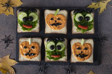 Cadılar Bayramı partisi için yeşil canavarlı ve korkunç balkabaklı sandviçler.