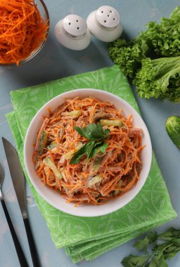 Salata, havuç, salatalık ve mayonez kaplı beyaz kase.