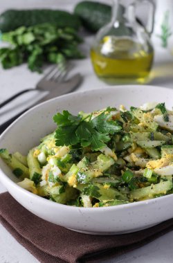 Kalamar, salatalık, yumurta ve yeşil soğanlı salata. Gri arka planda zeytin yağı ile kaplanmış.