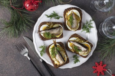 Kahverengi zemin üzerinde yumurta, peynir ve salatalık turşusu olan ev yapımı sıcak sandviçler.