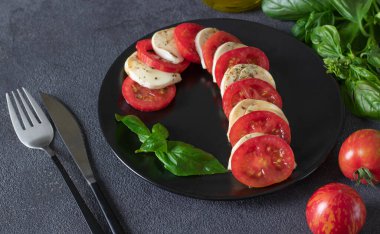 Baston şeklinde İtalyan Caprese salatası, domates, mozzarella peyniri, fesleğen ve zeytinyağı.