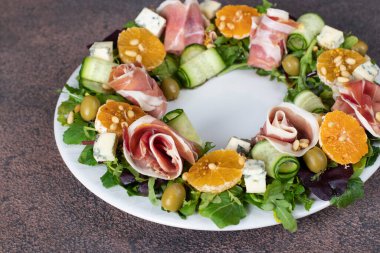 Jambon, mandalina, roka, mor peynir, salatalık ve çam fıstığı ile çelenk şeklinde salata.