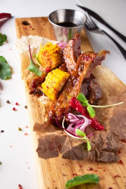 Tahtada mısırla servis edilen domuz pirzolası.