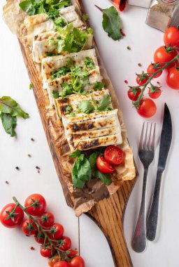 Tavuklu lavaş, ızgarada pişmiş, ahşap tahtada servis edilmiş.