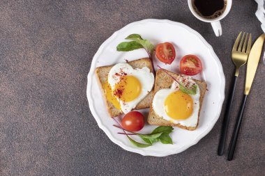 Kalp şeklinde kızarmış yumurta, vişneli domates ve kahvaltıda bir fincan kahve.