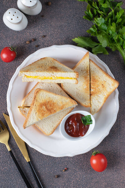 Sandwiches with egg and cheese fried in pan served with tomato sauce for breakfast, Top view