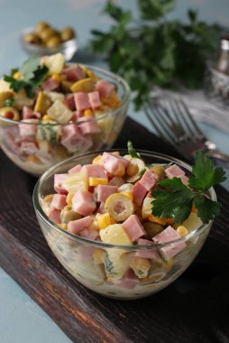 Salamlı salata, zeytin, mısır ve ananas şeffaf salata kaselerinde.