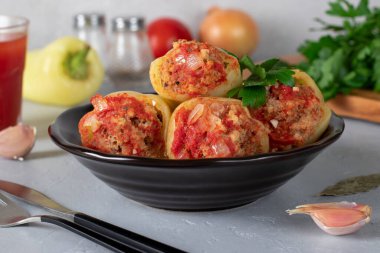 Pirinçle doldurulmuş Bell Pepper ve gri arka planda domates soslu kıyma.
