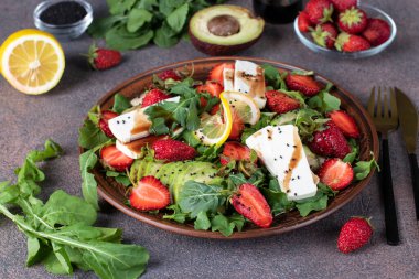 Limon ve balzamik soslu sağlıklı salata, avokado, roka ve peynir.