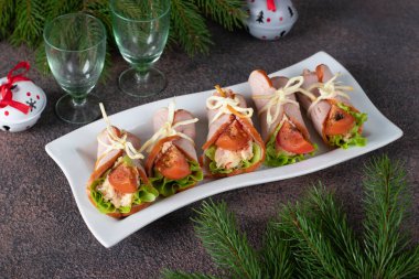 Peynirli jambon, yumurta, domates ve marul yapraklı beyaz tabak.