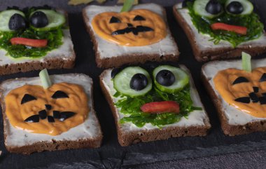 Cadılar Bayramı partisi için yeşil canavarlı ve korkunç balkabaklı sandviçler.