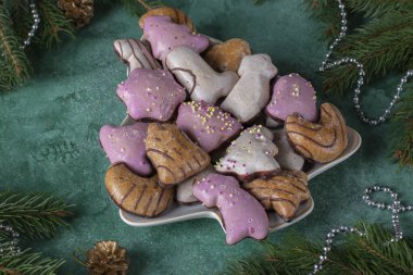 Geleneksel Alman zencefilli çöreği, yeşil arka planda Noel ağacı şeklinde tabakta çok renkli.