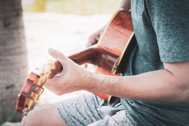 Gitarı dramatik bir tonda çalan insan.