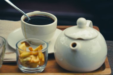 Tahta tabakta dramatik bir tonda kahve ve bisküvi.