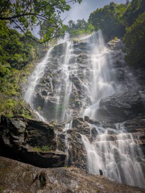 Tayland 'daki şelalenin atmosferi dramatik bir tonda.
