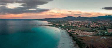 San Teodoro sand beach and village at coastline in Sadinia Italy from above during sunset, clouds in sky