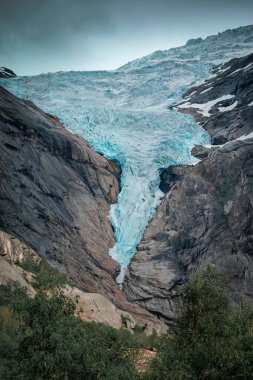Briksdalsbreen glacier in the mountains of Jostedalsbreen national park in Norway, blue ice melting in summer