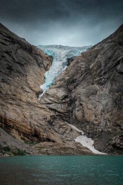 Briksdalsbreen glacier ice in the mountains of Jostedalsbreen national park in Norway, turquoise glacier lake