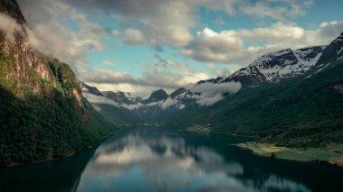 Aerial view of landscape panorama of fjord at Briksdalsbreen glacier in Jostedalsbreen mountains during summer, clouds in blue sky