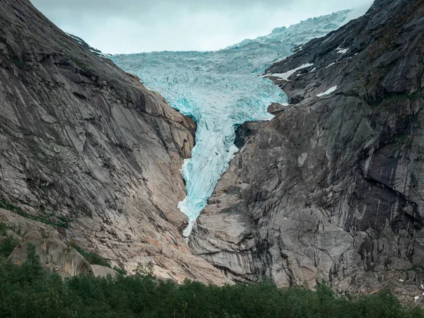 Briksdalsbreen glacier in the mountains of Jostedalsbreen national park in Norway, blue ice melting in summer