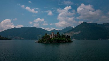 Isola di Loreto adasındaki kale, Iseo Gölü 'ndeki dağlar, mavi gökyüzü gününde, İtalya