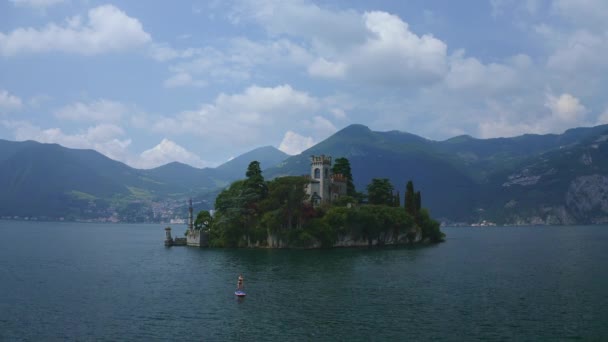 イオス湖の島イソラ ロレトの城のそばに立って 青空の日 イタリアの背景にある山々をズームアウト — ストック動画