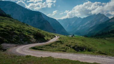 Yazın güneşli mavi gökyüzü gününde Karwendel dağlarındaki vadide yürüyüş yapan adam, gökyüzünde beyaz bulutlar, Tyrol Avusturya