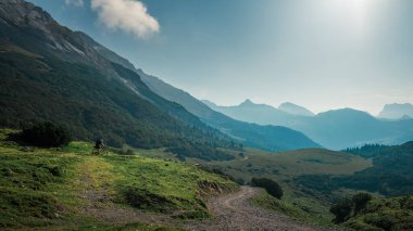 Yazın güneşli mavi gökyüzü gününde Karwendel dağlarında bisikletle gezen adam, Tyrol Avusturya